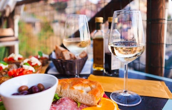 Romantisk middag med hvidvin og italienske antipasti ved solnedgang i Manarola, Cinque Terre