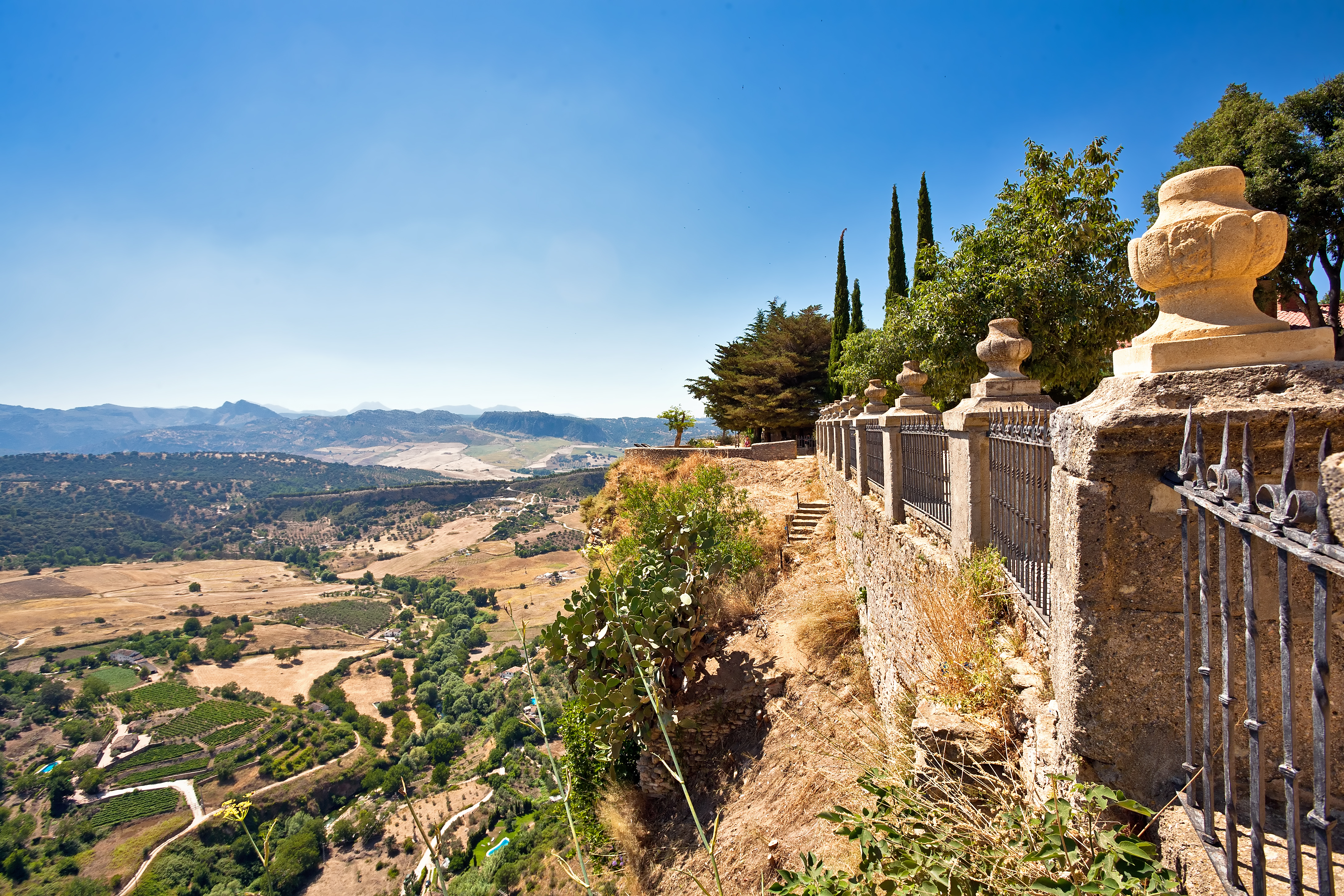 Historisk bro og gamle mure i Ronda med panoramaudsigt over Andalusiens dramatiske landskab