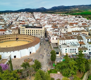 Luftfoto af den historiske tyrefægterarena Plaza de Toros og middelalderbyen Ronda, en berømt hvid by i Andalusien, Spanien