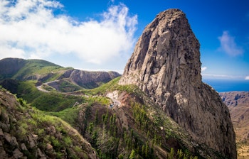 Imponerende udsigt over Roque Agando, en majestætisk basaltklippe på La Gomera i De Kanariske Øer, omgivet af frodige grønne dale