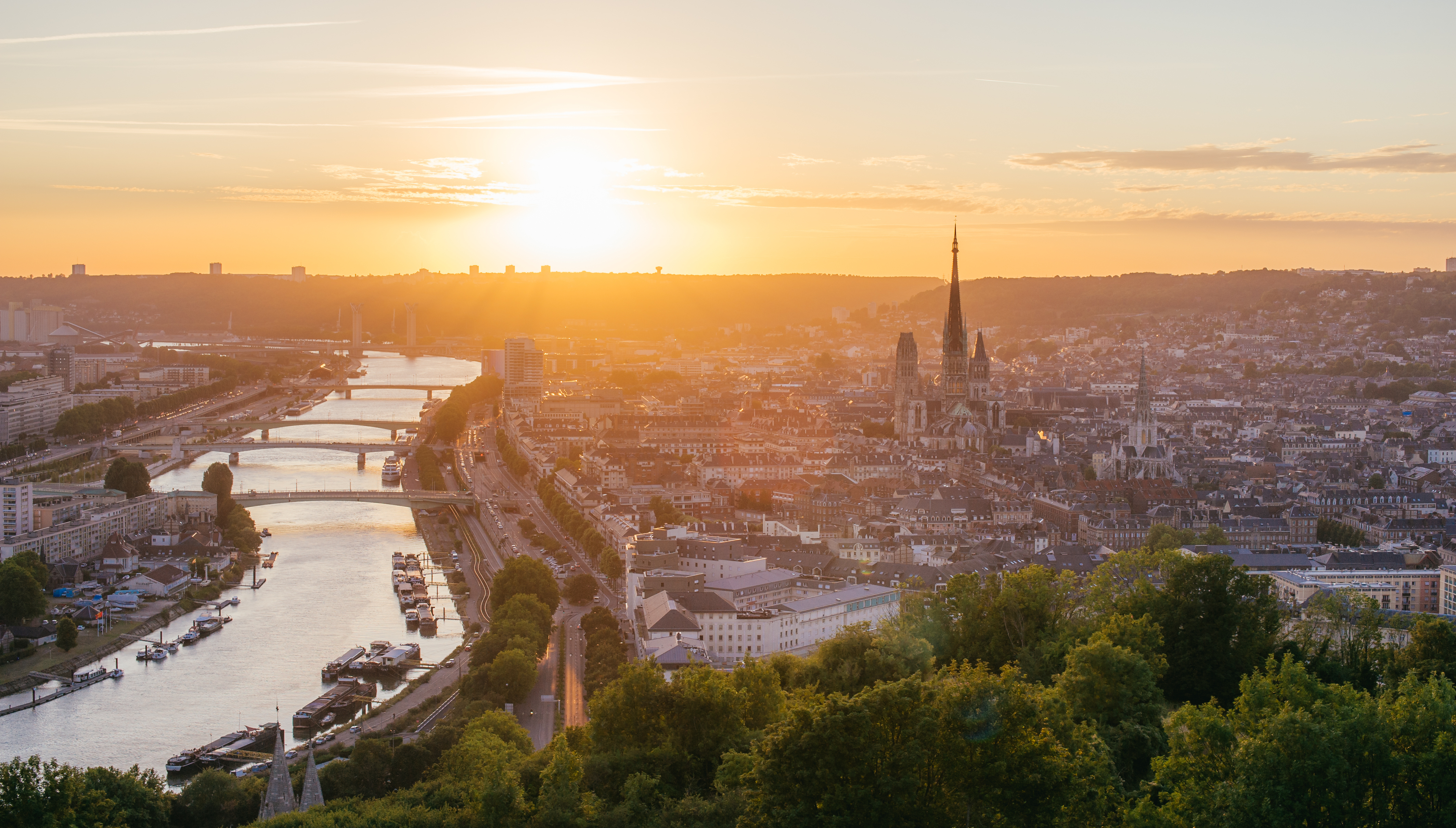 Panoramaudsigt over Rouen i Normandiet med den gotiske katedral og Seine-floden badet i gyldent solnedgangslys