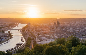 Panoramaudsigt over Rouen i Normandiet med den gotiske katedral og Seine-floden badet i gyldent solnedgangslys