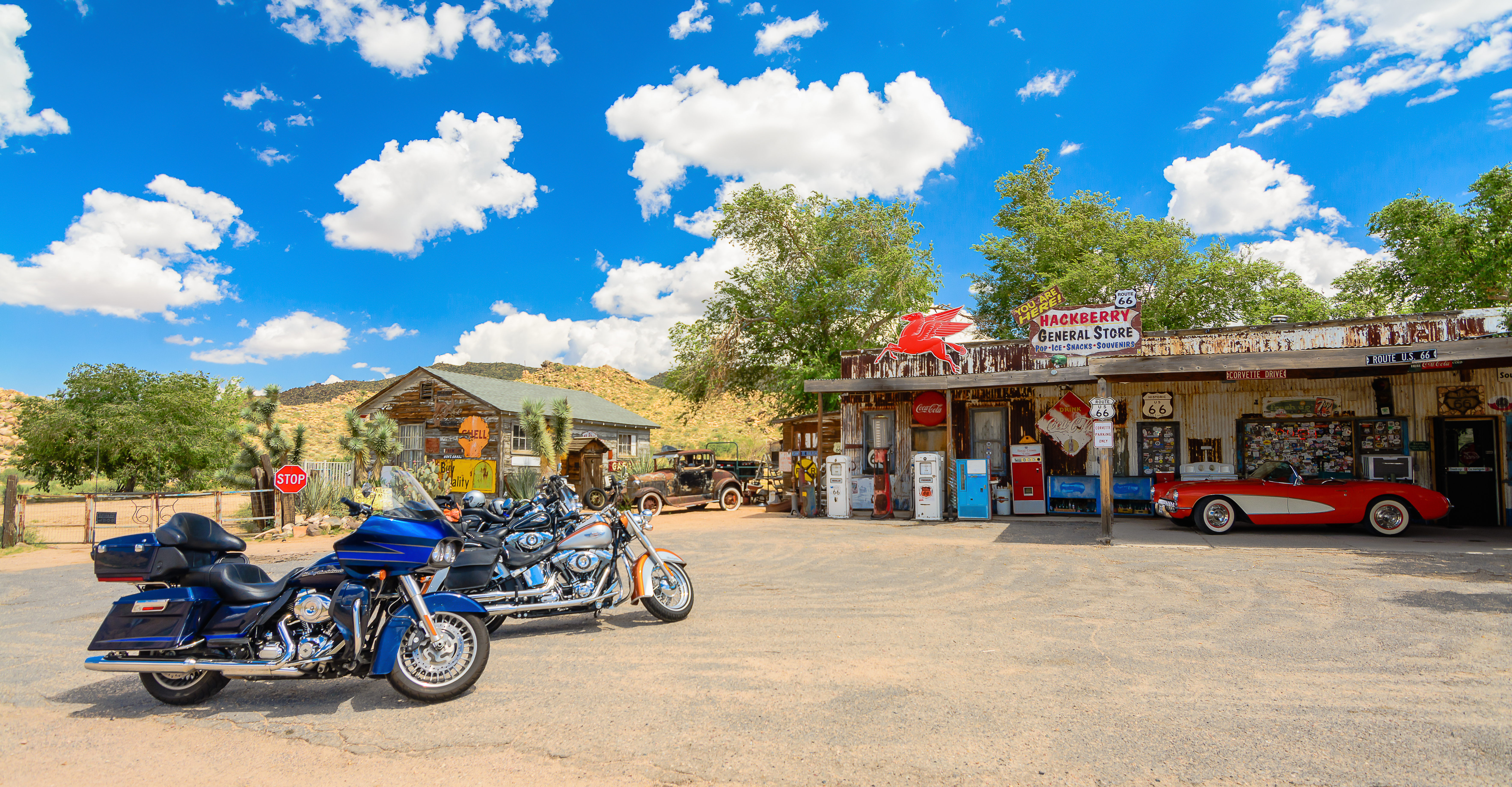 Historisk benzinstation på Route 66 i Arizona med klassisk rød Corvette og motorcykler