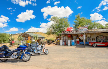 Historisk benzinstation på Route 66 i Arizona med klassisk rød Corvette og motorcykler