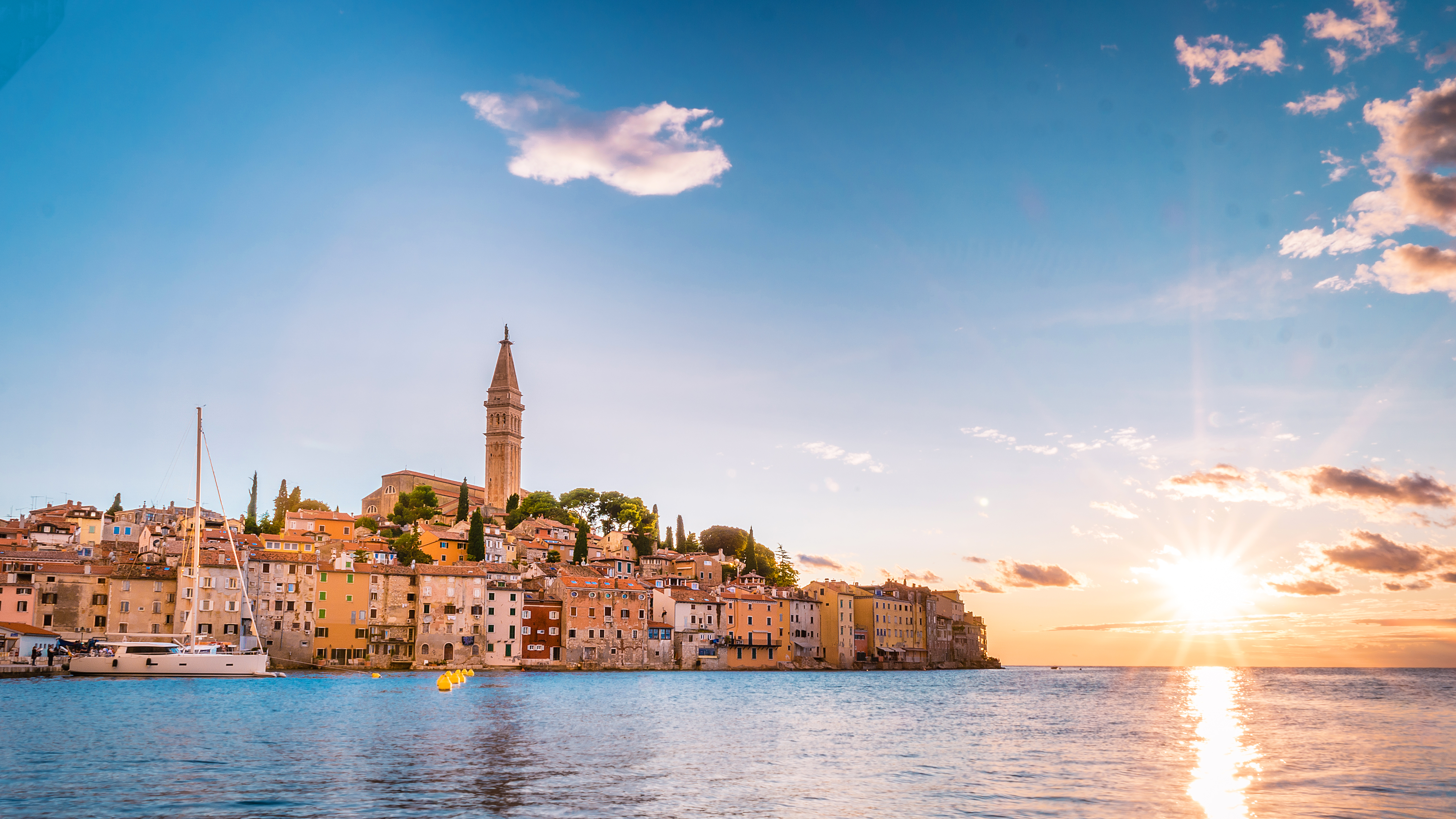 Malerisk solnedgang over den gamle bydel i Rovinj, Istrien med det ikoniske kirketårn og farverige bygninger ved Adriaterhavets kyst