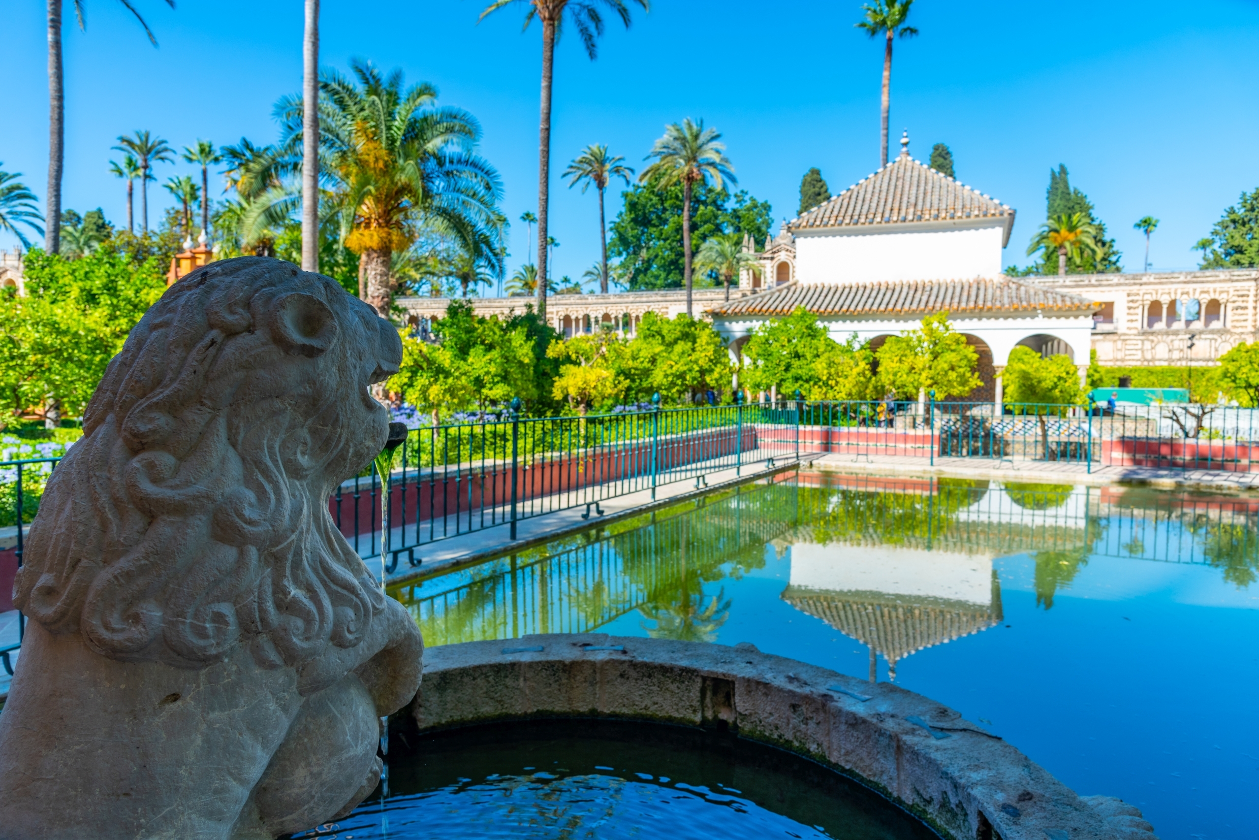 Løvestatue ved spejldam i Royal Alcazar palæhave i Sevilla Spanien