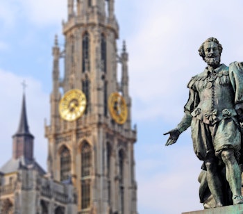 Historisk bronzestatue af den flamske maler Peter Paul Rubens med den gotiske Vor Frue Katedral i baggrunden i Antwerpen, Belgien