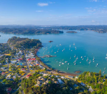Luftfoto af Russell Bay på New Zealand med sejlbåde og kystby