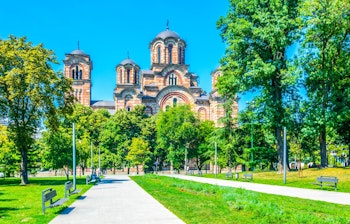 Den ortodokse Saint Mark kirke i Beograd med grøn park og blå himmel, et historisk landemærke i Serbien