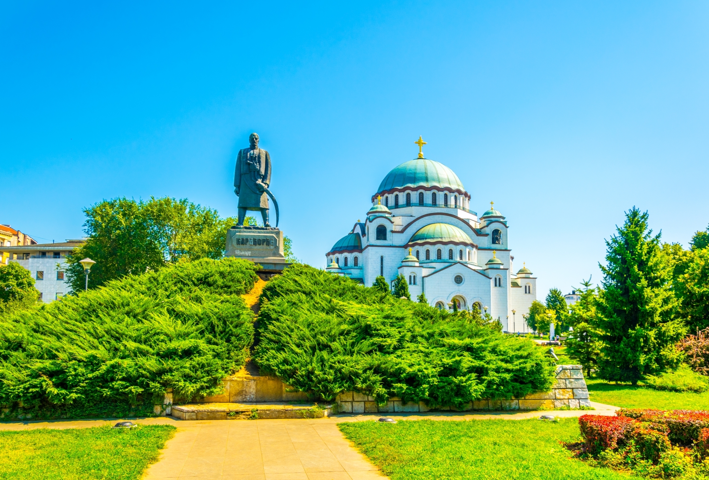 Saint Sava Katedral med monument i Belgrade park på solrig dag