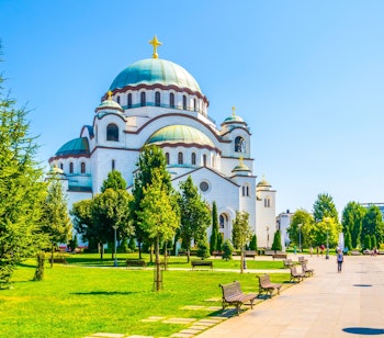 Saint Sava Katedralen i Beograd Serbien med hvide marmorfacader og blå kupler omgivet af grøn park