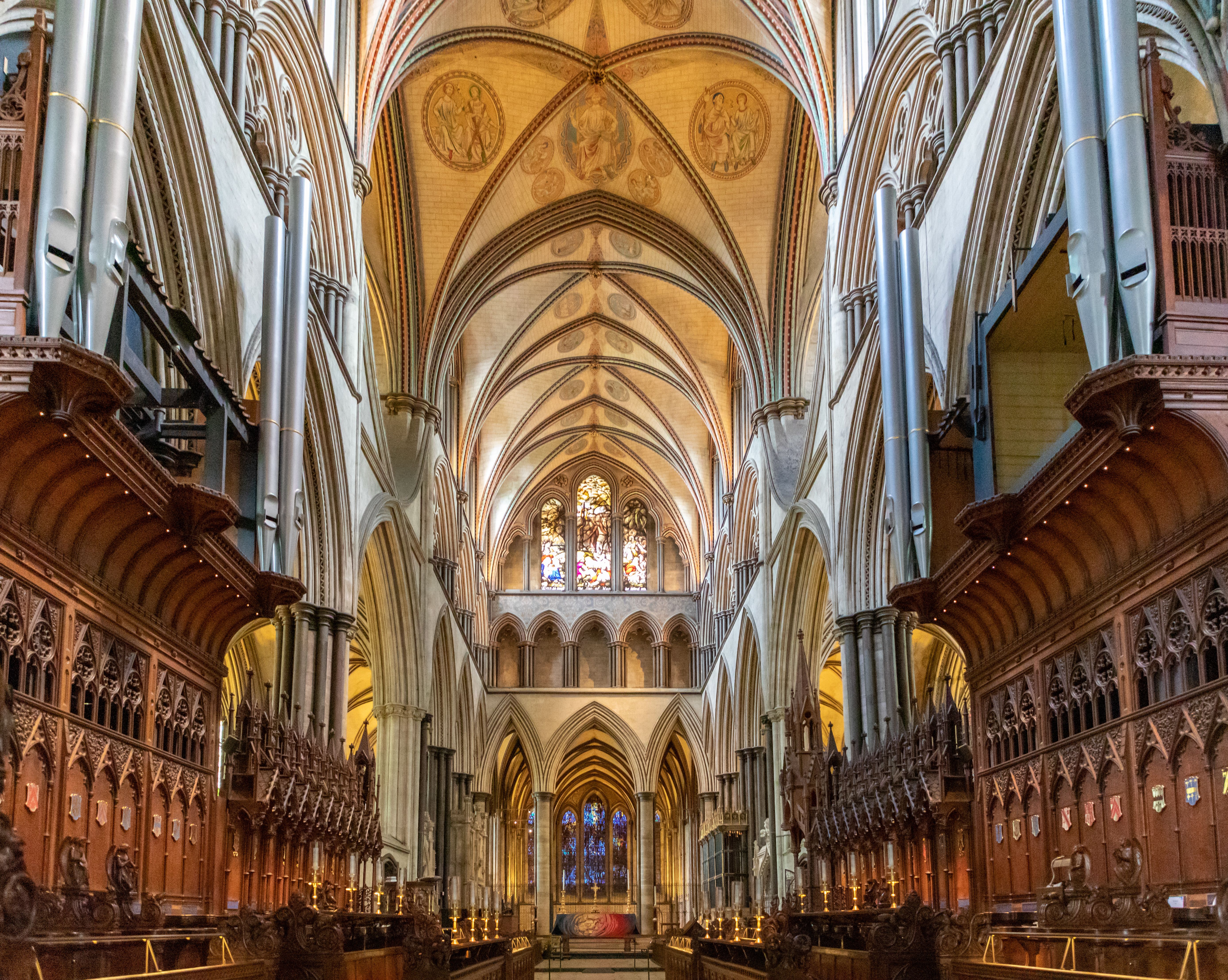 Imponerende gotisk interiør i Salisbury Cathedral med hvælvede lofter, udskårne korstole og farverige glasmalerier i England
