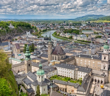 Flot panoramaudsigt over Salzburgs historiske bykerne med barok domkirke og fæstning ved Salzach floden i Østrig