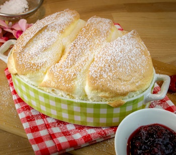 Traditionel Salzburger Nockerl, en luftig østrigsk soufflé-dessert drysset med flormelis, en berømt kulinarisk specialitet fra Salzburg der serveres varm