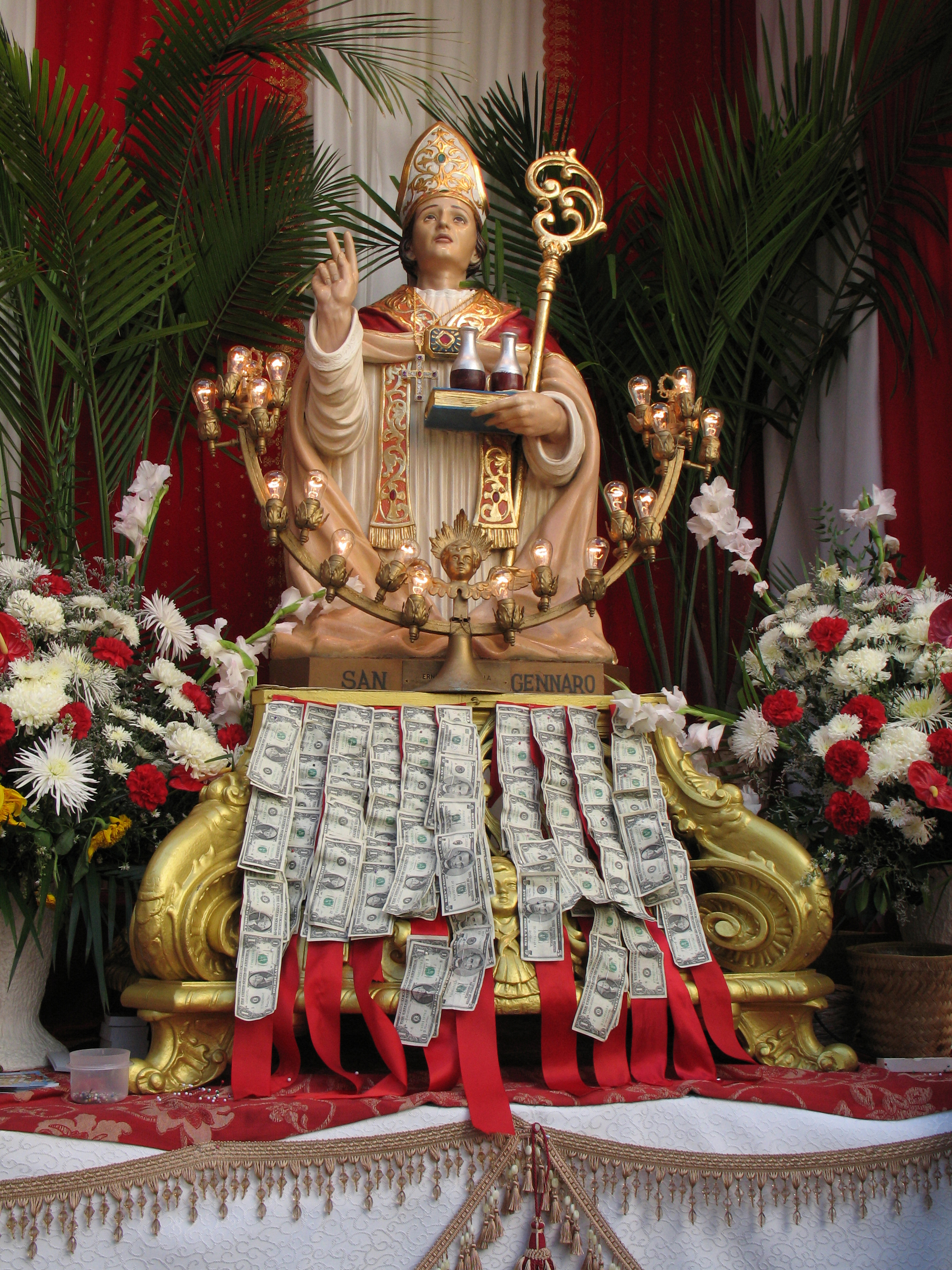 Gylden statue af San Gennaro med ceremonielle udsmykninger ved en religiøs festival i Syditalien, der viser regionens rige katolske traditioner.