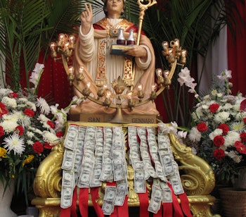 Gylden statue af San Gennaro med ceremonielle udsmykninger ved en religiøs festival i Syditalien, der viser regionens rige katolske traditioner.