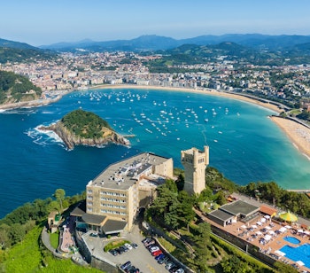 Luftfoto over San Sebastians bugt med La Concha stranden, Monte Igueldo tårnet og turkisblåt atlanterhavsvand i Baskerlandet, Spanien