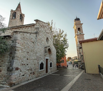 Den historiske San Severo-kirke med klokketårn ved solopgang i Bardolino ved Gardasøen. Middelalderlig romansk arkitektur i Norditalien.