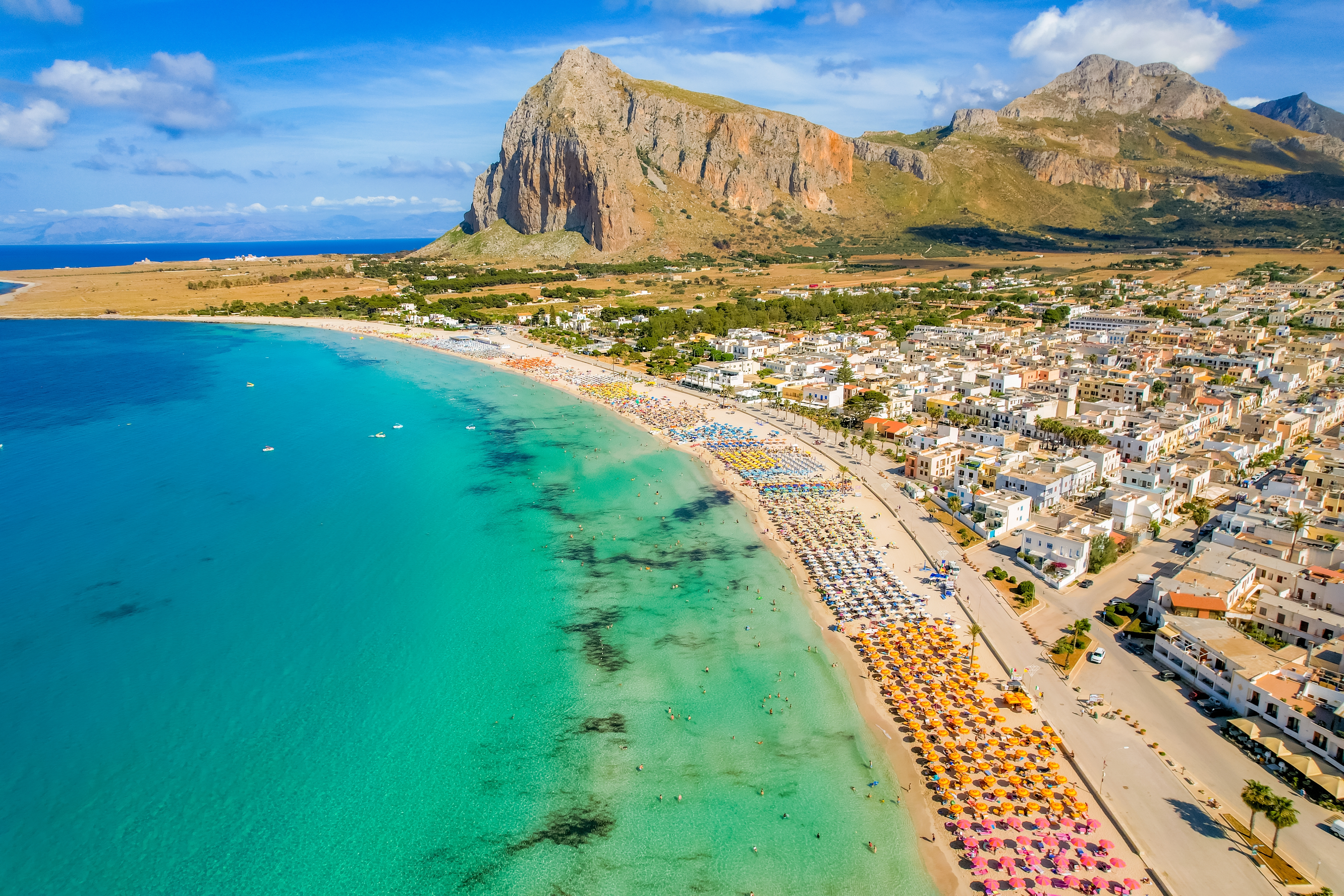 Idyllisk sandstrand ved San Vito lo Capo med Monte Monaco bjerget i baggrunden, krystalklart blåt vand og gyldent sand på Siciliens nordvestlige kyst