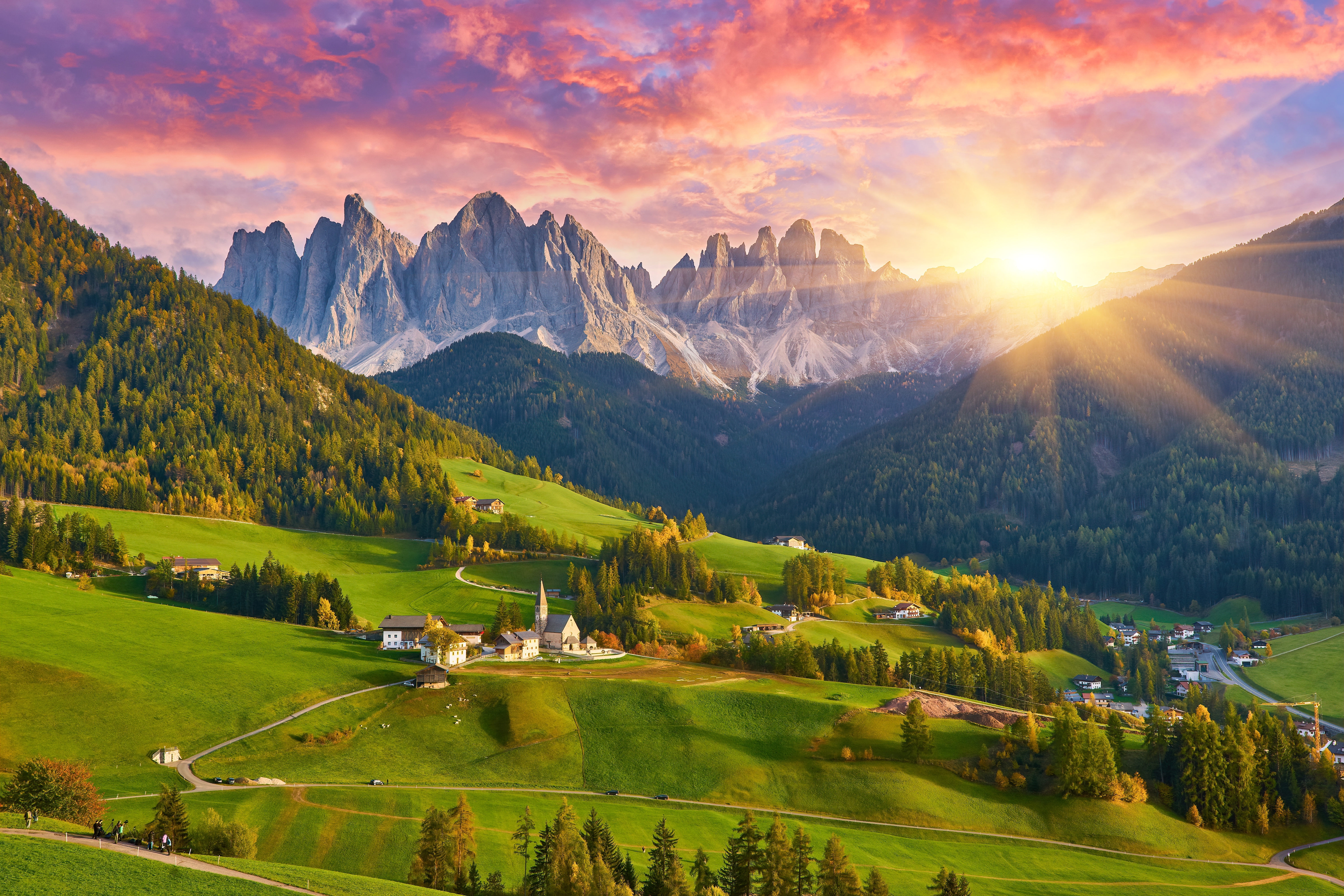 Magisk solopgang over Santa Maddalena landsbyen i Dolomitterne, Sydtyrol, Italien, med farverige efterårstræer, grønne enge og dramatiske bjergtinder