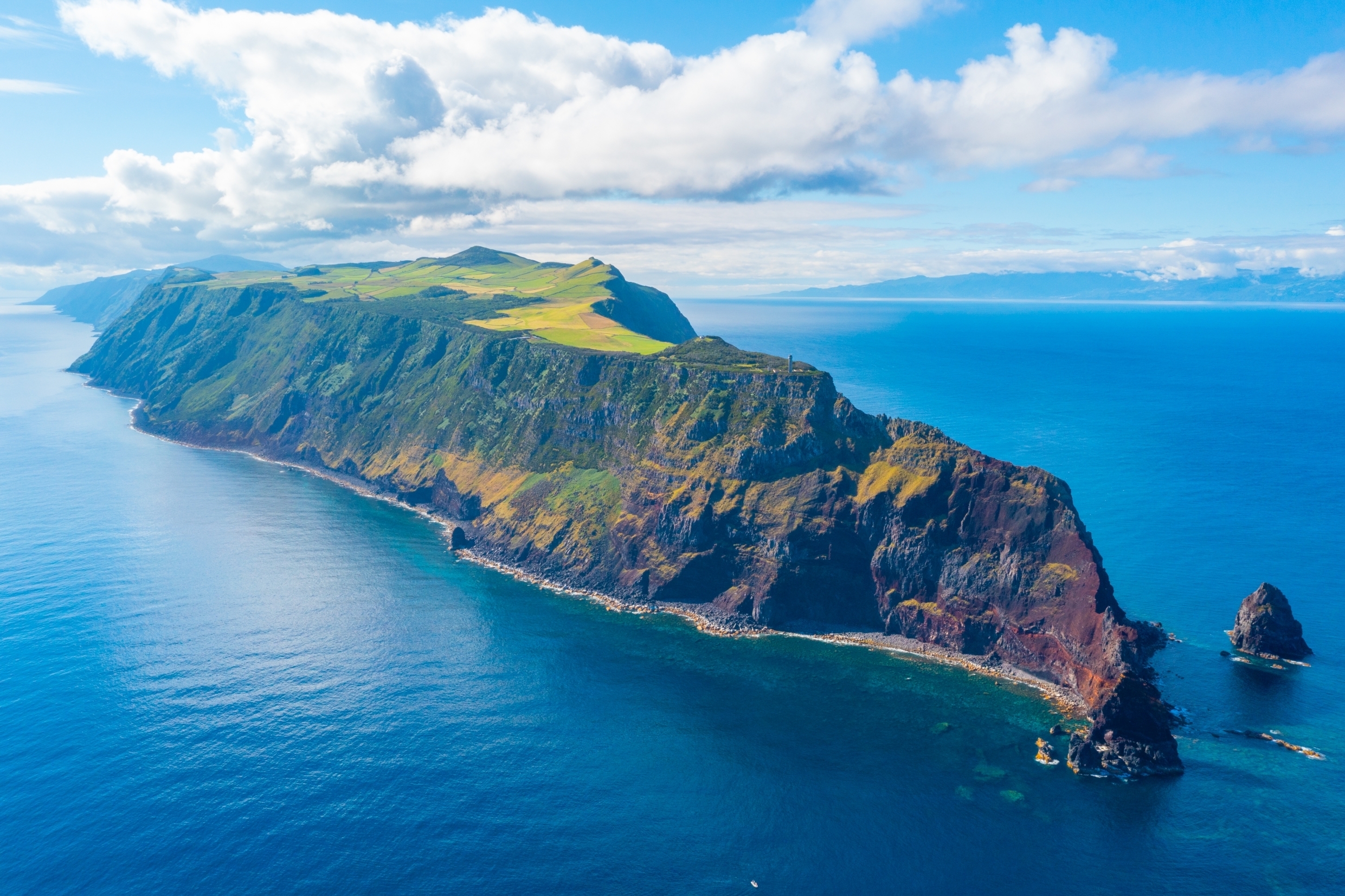Betagende panoramaudsigt over São Jorge øen i Azorerne, Portugal - dramatiske vulkanske klipper møder frodige grønne bakker og det dybblå Atlanterhav i dette naturparadis