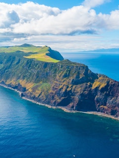 Betagende panoramaudsigt over São Jorge øen i Azorerne, Portugal - dramatiske vulkanske klipper møder frodige grønne bakker og det dybblå Atlanterhav i dette naturparadis
