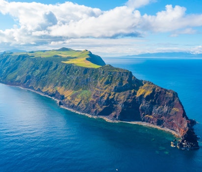 Betagende panoramaudsigt over São Jorge øen i Azorerne, Portugal - dramatiske vulkanske klipper møder frodige grønne bakker og det dybblå Atlanterhav i dette naturparadis