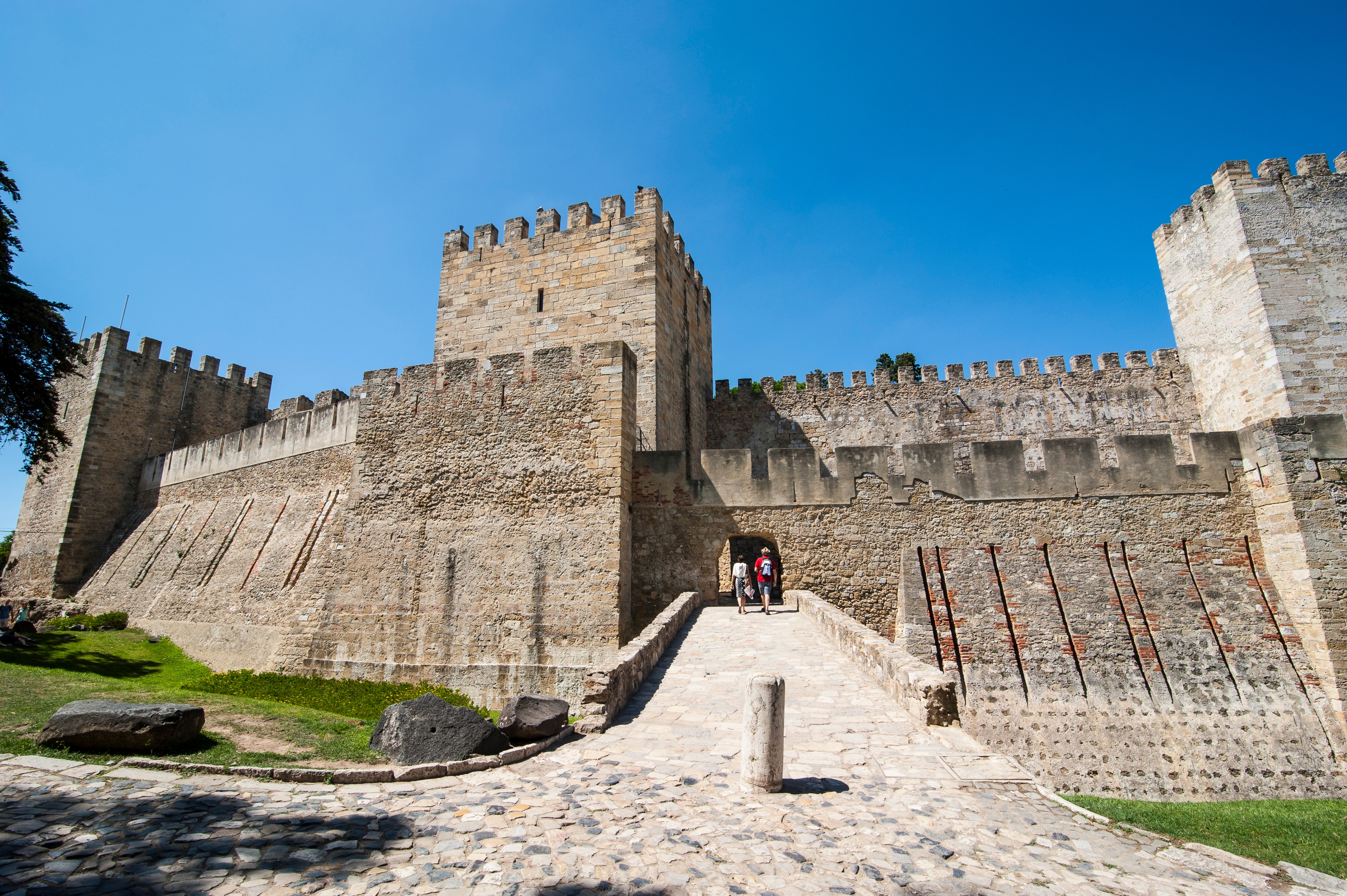 Castelo de Sao Jorge med historiske bymure og tinder under blå himmel i Lissabon, Portugal