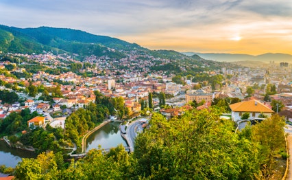 Betagende panoramaudsigt over Sarajevo i solnedgangslys set fra den Gule Fæstning (Žuta Tabija) i Vratnik-området, Bosnien-Hercegovina