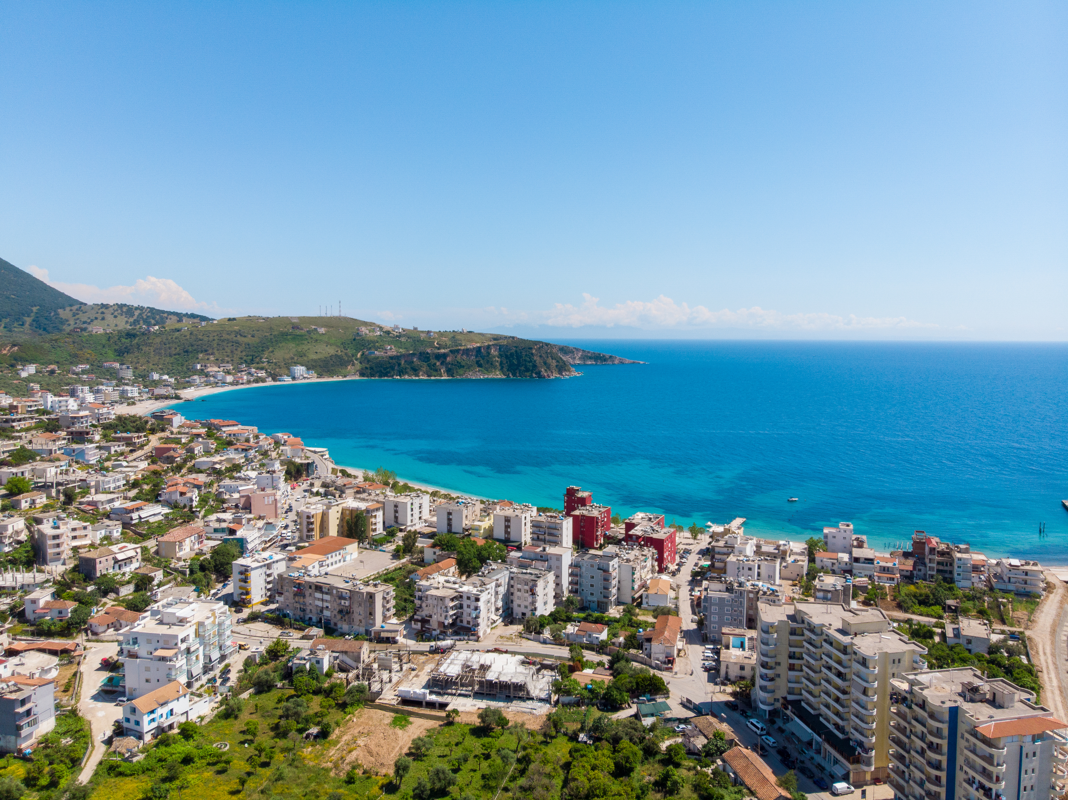 Luftfoto af Saranda i Albanien med turkisblåt hav og hvide bygninger langs den smukke Ioniske kyst