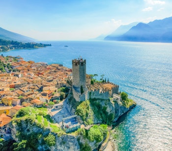 Det historiske Scaliger-slot i Malcesine med udsigt over Gardasøen og bjergene i baggrunden