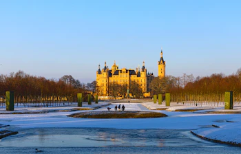 Schwerin Slot om vinteren med frossen sø og snedækkede slotshaver i Tyskland