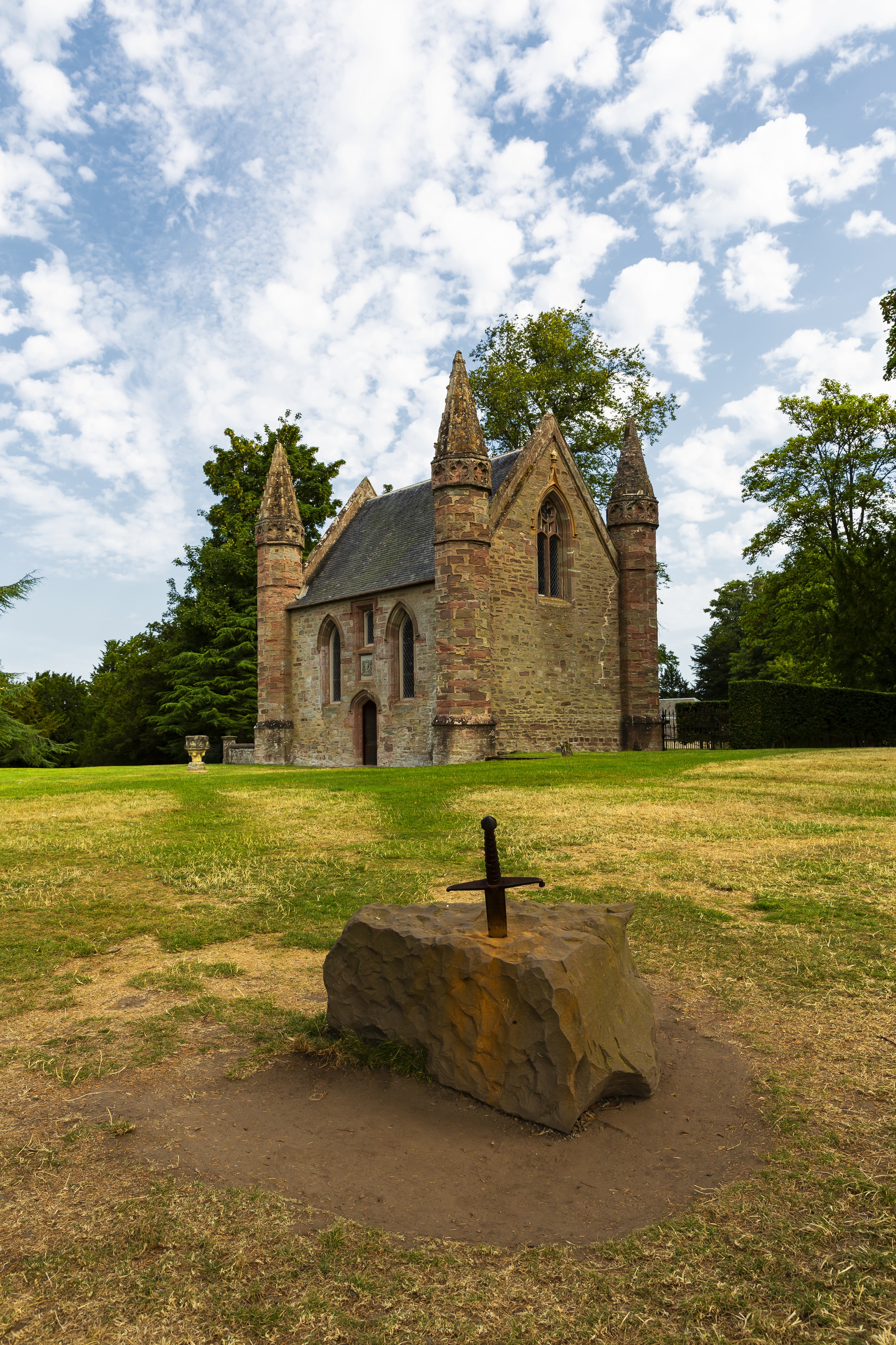 Det majestætiske Scone Palace i Perth, Skotland - en imponerende historisk bygning med røde sandstensdetaljer og smukke haver, kendt for kongelige kroninger