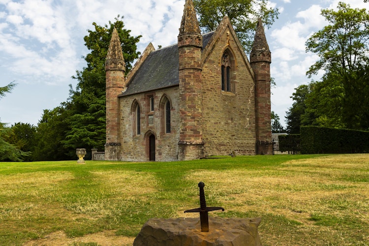 Det majestætiske Scone Palace i Perth, Skotland - en imponerende historisk bygning med røde sandstensdetaljer og smukke haver, kendt for kongelige kroninger
