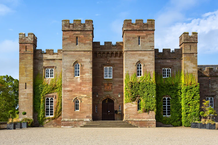 Panoramaudsigt over det historiske Scone Palace i Perth, Skotland, med imponerende nygotisk rød sandstensarkitektur og efeudækkede mure