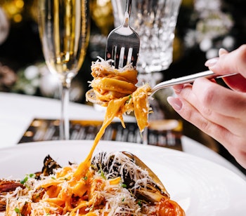 Lækker seafood pasta med rejer og muslinger serveret med champagne på Ristorante Hostaria Costanza i Rom, perfekt til en gastronomisk nytårsmiddag