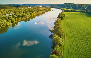 Betagende luftfoto af Seinen-floden der slynger sig gennem grønne marker i Val d'Oise, Ile-de-France i Nordfrankrig