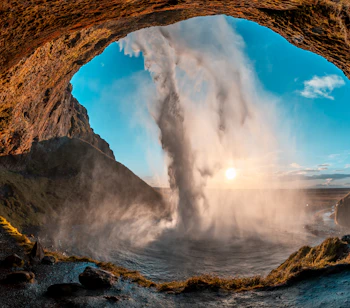 Det berømte Seljalandsfoss vandfald i Island under den gyldne time med magisk tåge og dramatisk naturlandskab