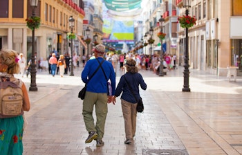 Ældre par nyder sightseeing i Malagas historiske gader under deres ferie i Andalusien, Spanien
