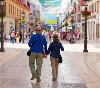 Ældre par nyder sightseeing i Malagas historiske gader under deres ferie i Andalusien, Spanien