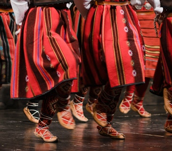 Traditionel serbisk kolo-folkedans med dansere i farverige røde og sorte dragter - en autentisk kulturel oplevelse fra Balkan