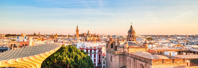 Sevillas smukke bysilhuet ved solnedgang med den moderne Metropol Parasol træstruktur i forgrunden, Andalusien, Spanien