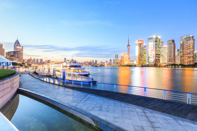 Shanghai skyline ved skumring med oplyste skyskrabere reflekteret i Huangpu-floden under aftenkrydstogt