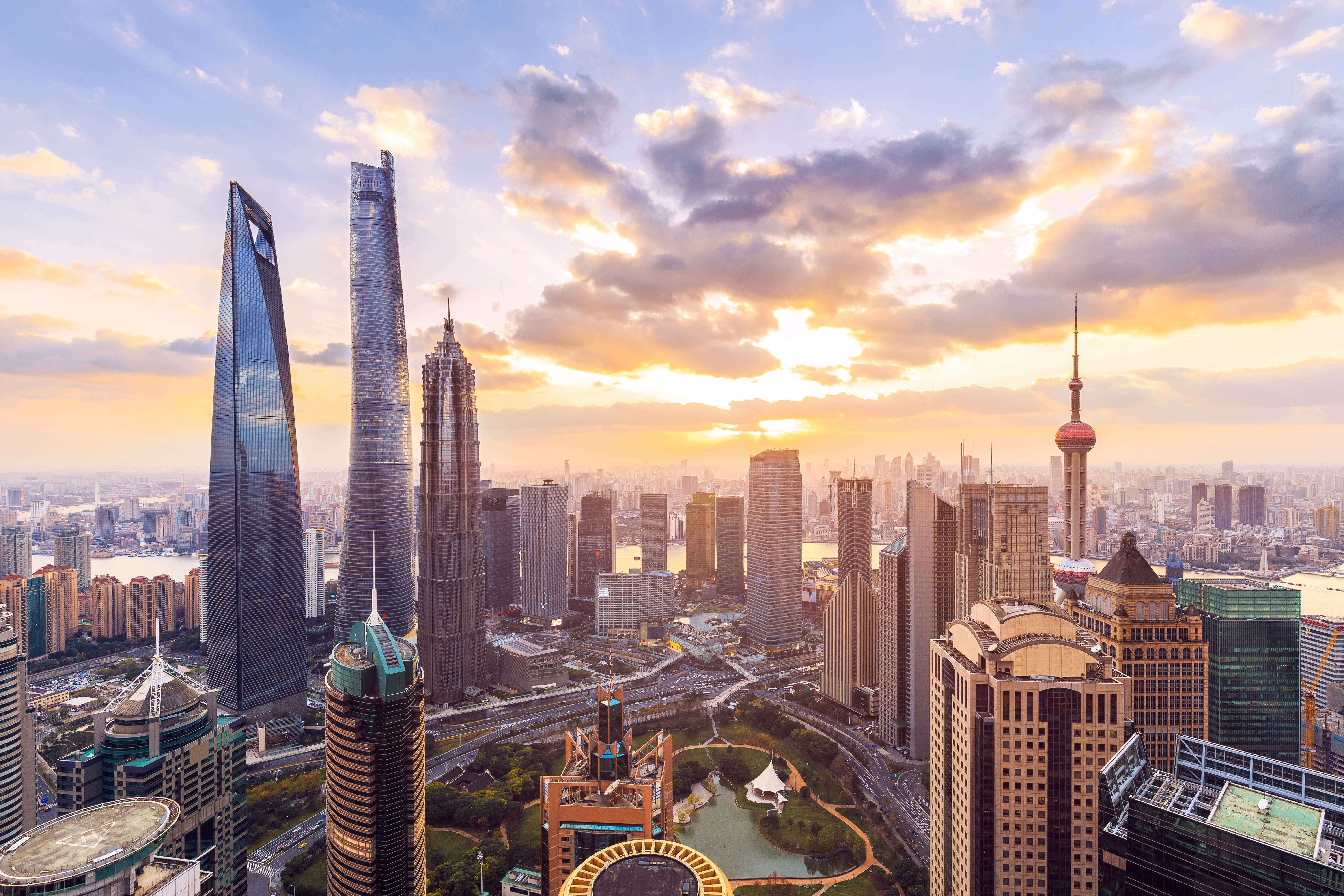 Shanghai skyline ved solnedgang med moderne skyskrabere og Oriental Pearl Tower