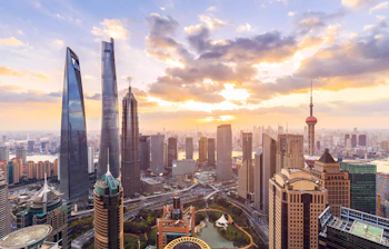 Shanghai skyline ved solnedgang med moderne skyskrabere og Oriental Pearl Tower