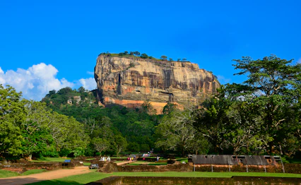 Sigiriya klippefæstning omgivet af grøn jungle under blå himmel i Sri Lanka