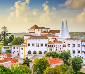 Det oplyste Sintra Nationalpalads med de ikoniske kegleformede skorstene i skumringen i den UNESCO-beskyttede by Sintra, Portugal