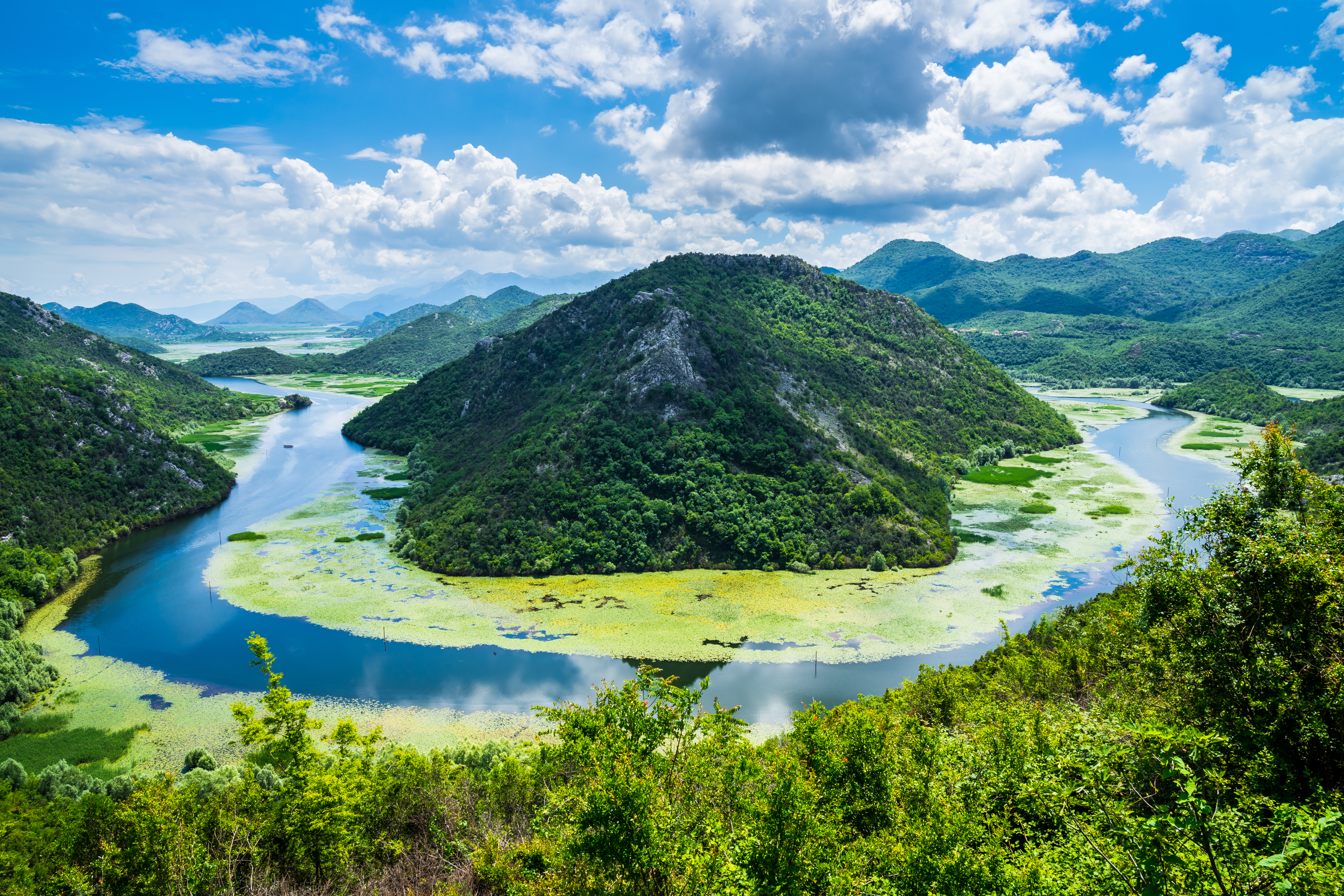 Panoramaudsigt over Skadar Søs snoede flod gennem grønne bjerge i Montenegro