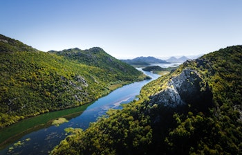 Luftfoto af Skadar Lake Nationalpark i Montenegro med grønne bjerge og bugtende flod