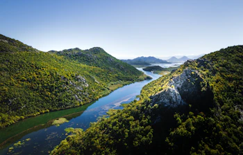 Luftfoto af Skadar Lake Nationalpark i Montenegro med grønne bjerge og bugtende flod